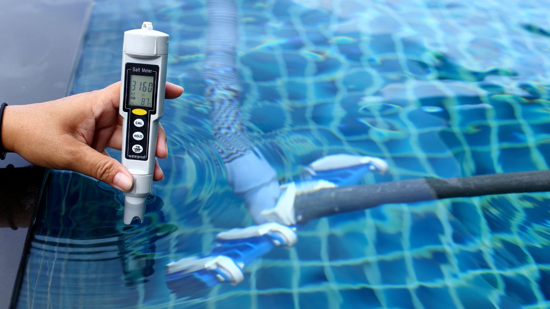 Salt meter measuring water salinity near blue swimming pool tiles