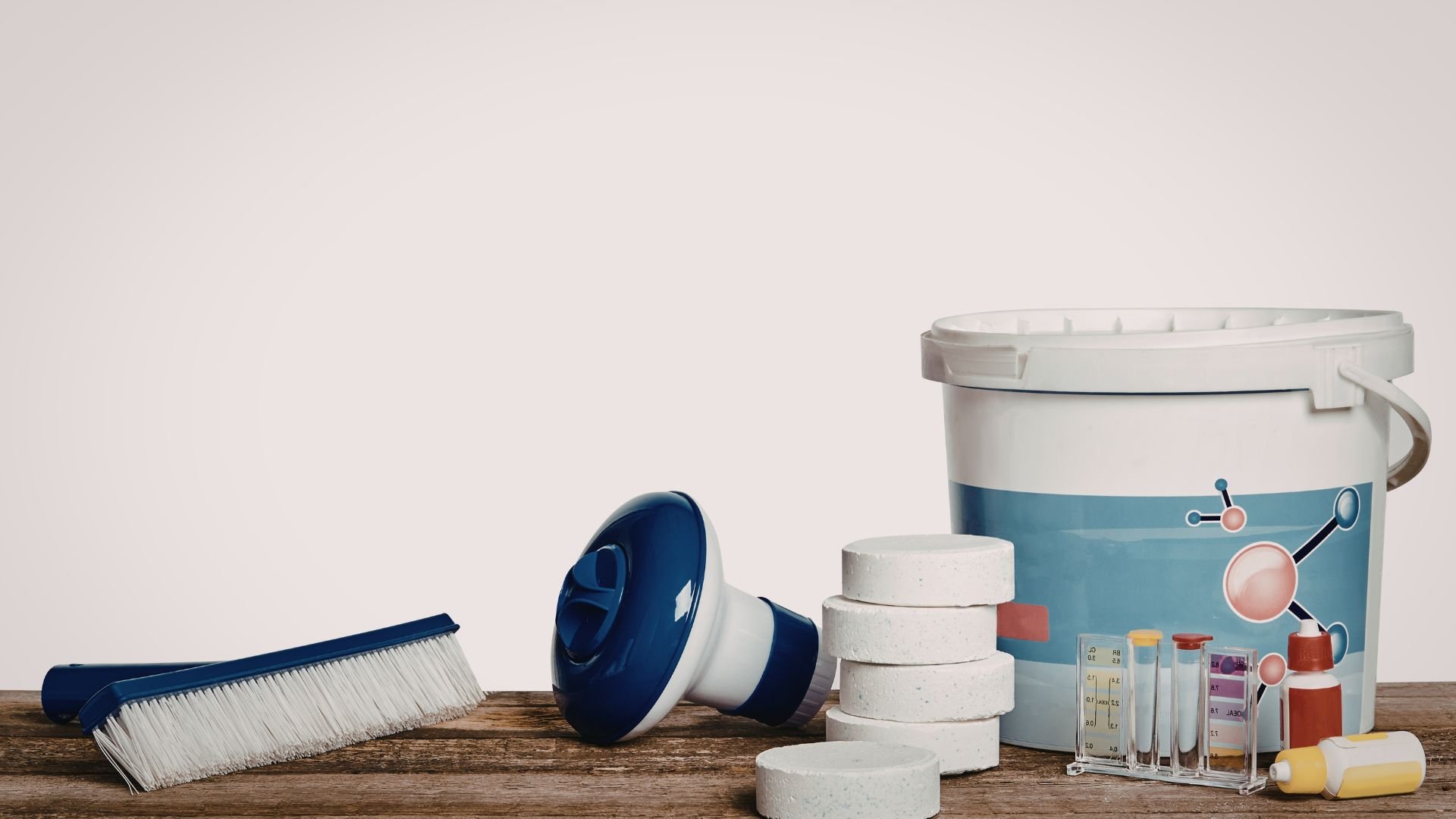 Pool cleaning supplies including brush, chemicals, test tubes, and large bucket