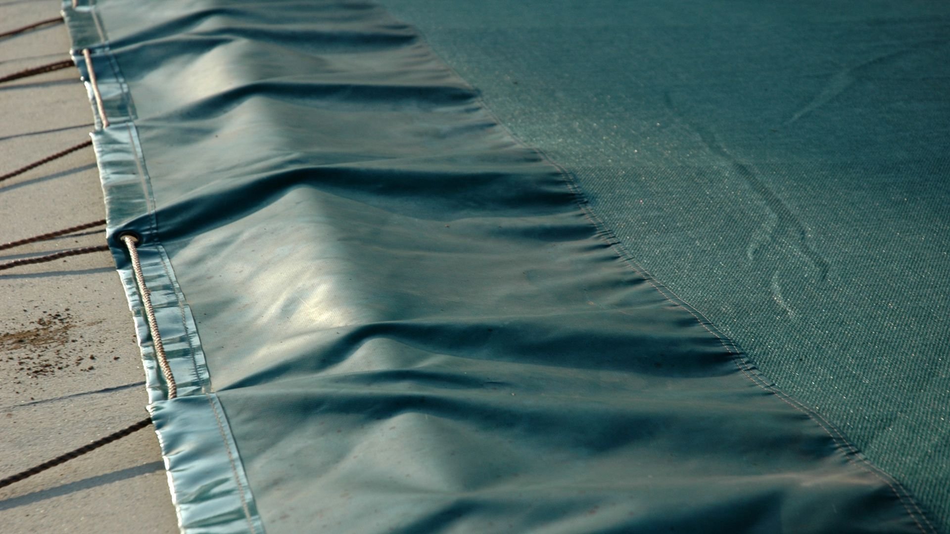 Close-up of folded teal fabric with detailed seams and stitching